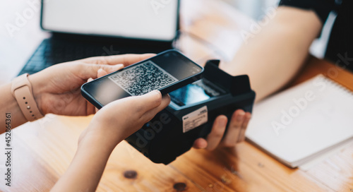 A woan using her mobile to made a payment wireless with EDC machine or credit card terminal. Mobile payment concept with virtual credit card photo