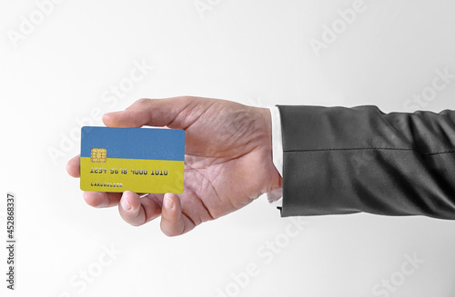 Bank credit plastic card with flag of Ukraine holding man in elegant suit