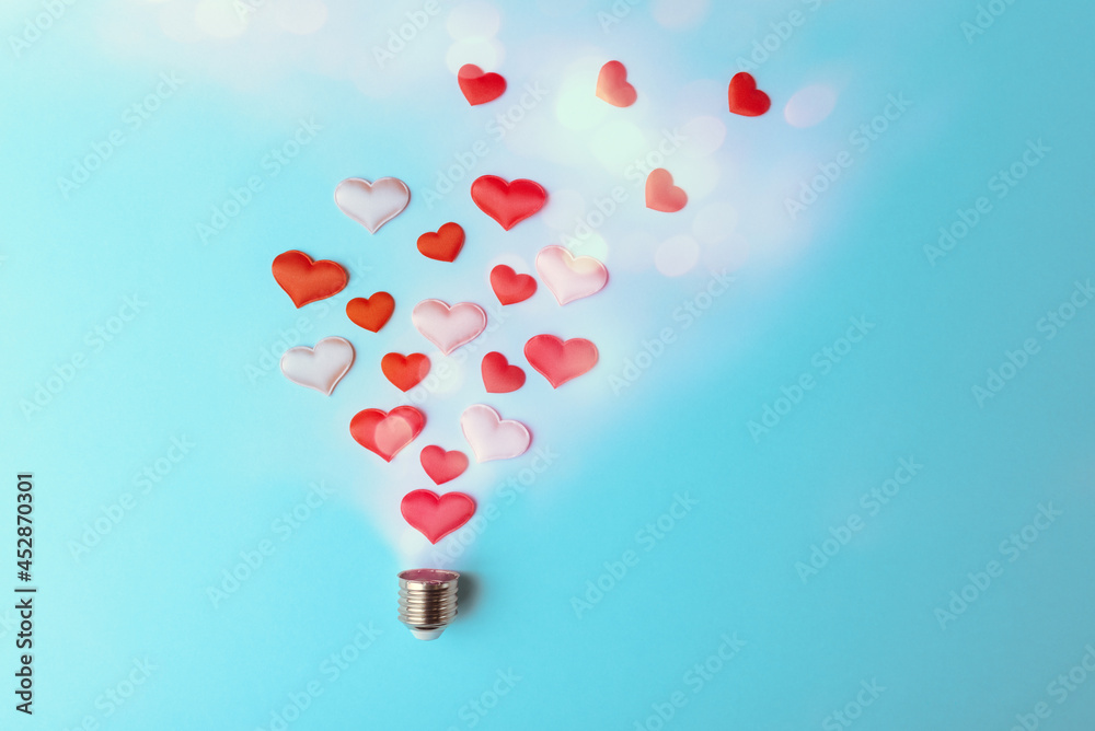 Valentine hearts in bulb cap on light blue background. Love and Valentine’s day conceptual greeting