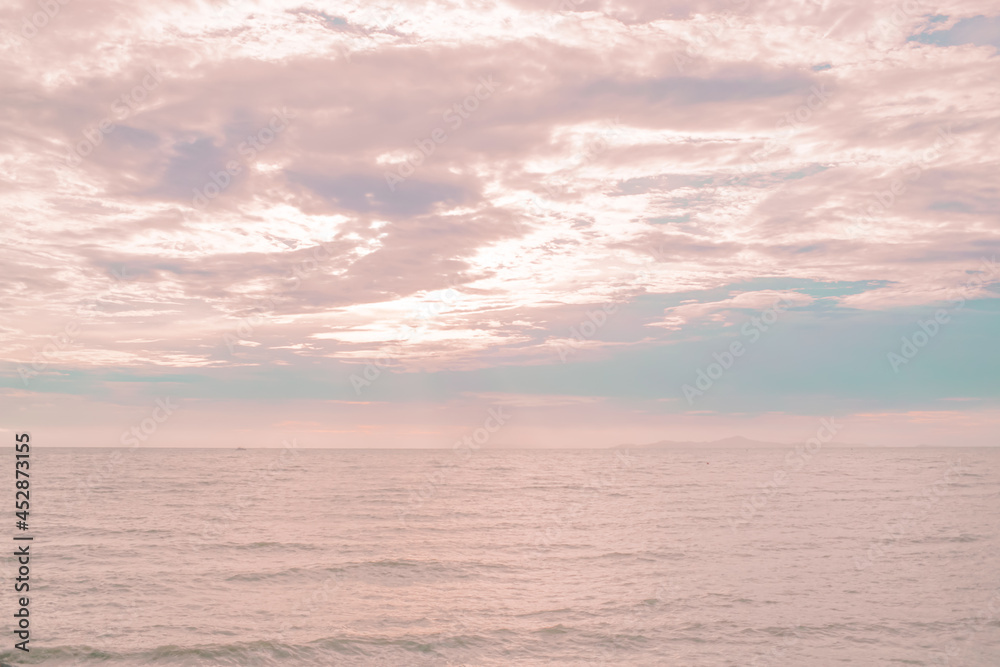 sunset over the sea with a pastel sky of pink.