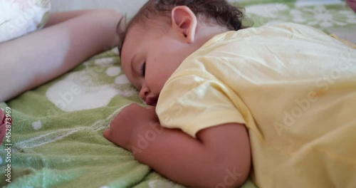 cute little boy sleeps sweetly in crib and sees colorful dreams in bedroom while sleeping at home