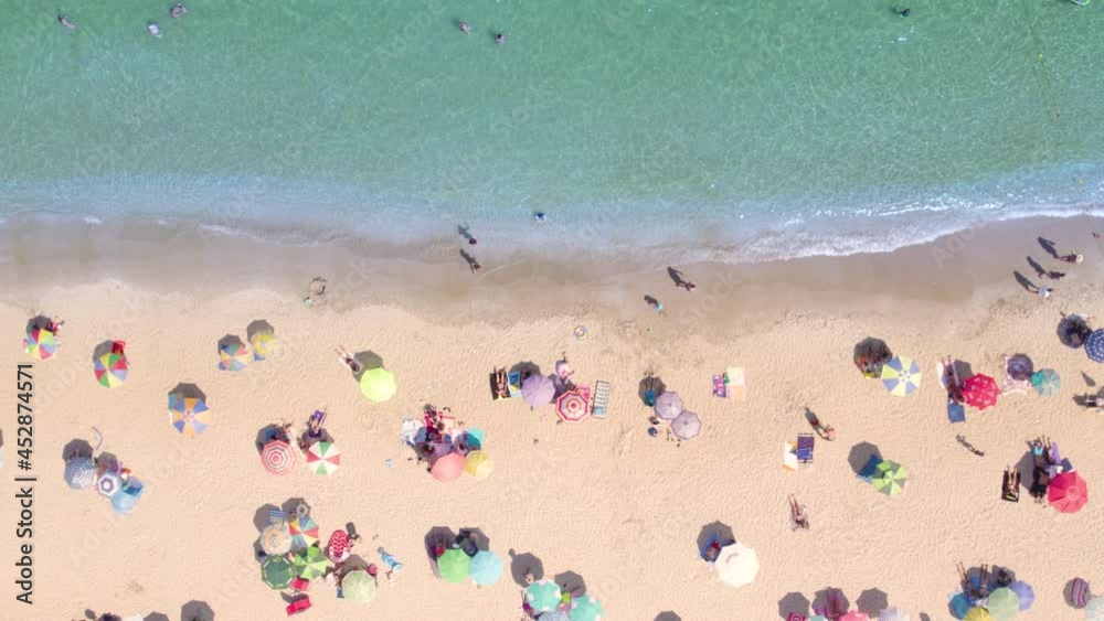 Aerial top view of crowded sand beach and calm azure sea water Aerial top view of crowded sand beach and calm azure sea water