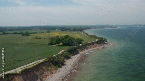 Wallpaper Mural Circle pan aerial drone view of shoreline beach with vast green field in Brodten, Germany on peaceful spring day Torontodigital.ca