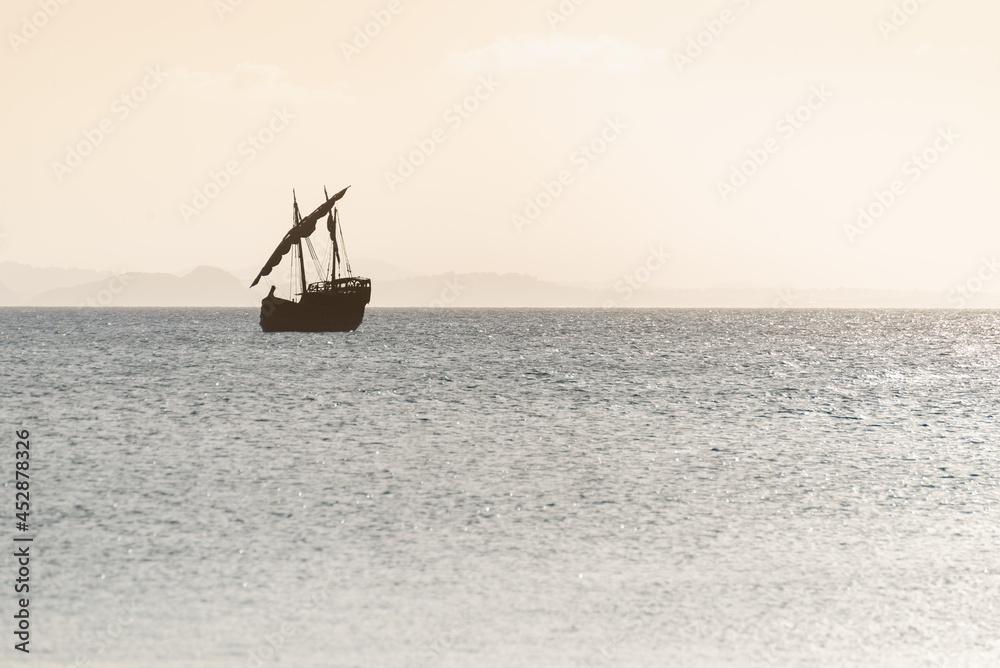 Silhouette of Sailing Ship on Ocean Against Mountains.Adventure Concept Silhouette of Sailing Ship on Ocean Against Mountains.Adventure Concept