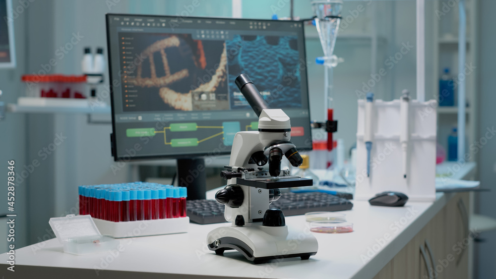 Scientific microscope on laboratory desk with researching instruments at professional workplace. Close up of investigation tool with glass lens for chemical substance lab examination Scientific microscope on laboratory desk with researching instruments at professional workplace. Close up of investigation tool with glass lens for chemical substance lab examination