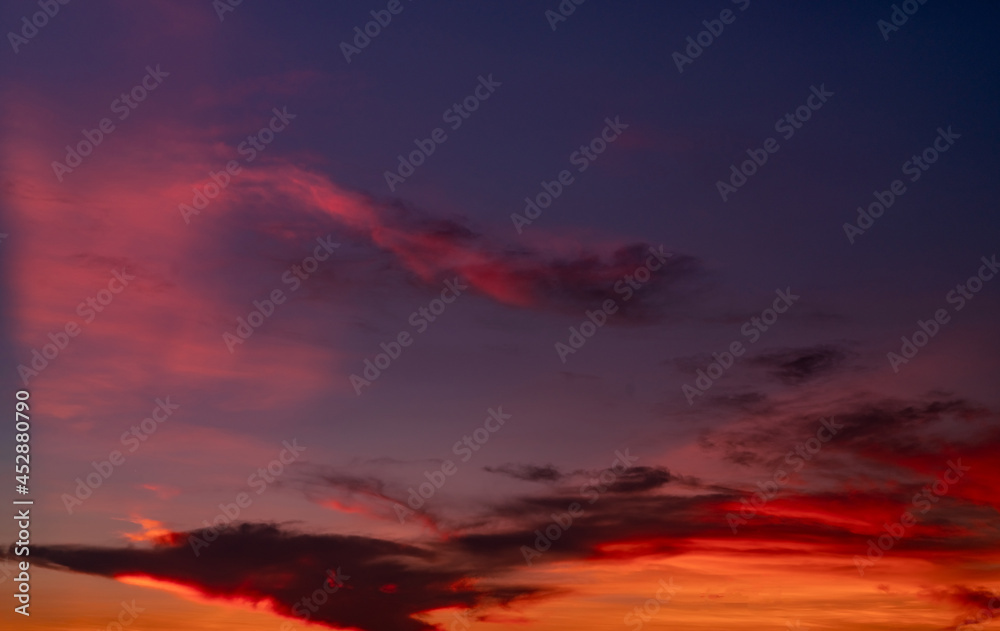 Dramatic red and dark blue sky and clouds texture background. Red, purple and orange clouds on sunset sky. The sky at dusk. Sunset abstract background. Dusk and dawn. Color of nature. Freedom concept.