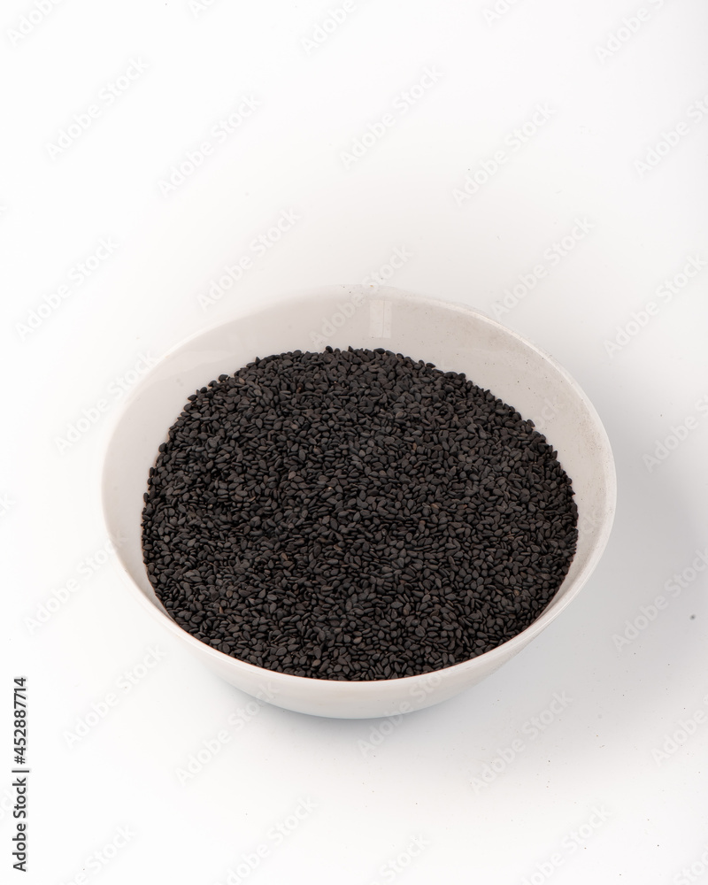 Black sesame seeds in a white plate isolated on a white background. High quality photo Black sesame seeds in a white plate isolated on a white background. High quality photo