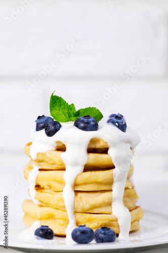 Blueberry Pancakes With Yoghurt and Mint on white background, Traditional American Healthy Breakfast, Copyspace, Vertical Resolution