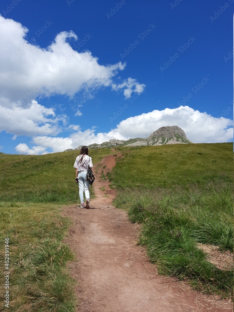Girl walking on the mountain road Girl walking on the mountain road