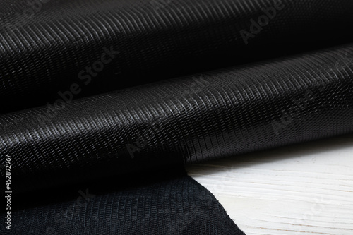 Black textured colored folded natural leather on the wooden table