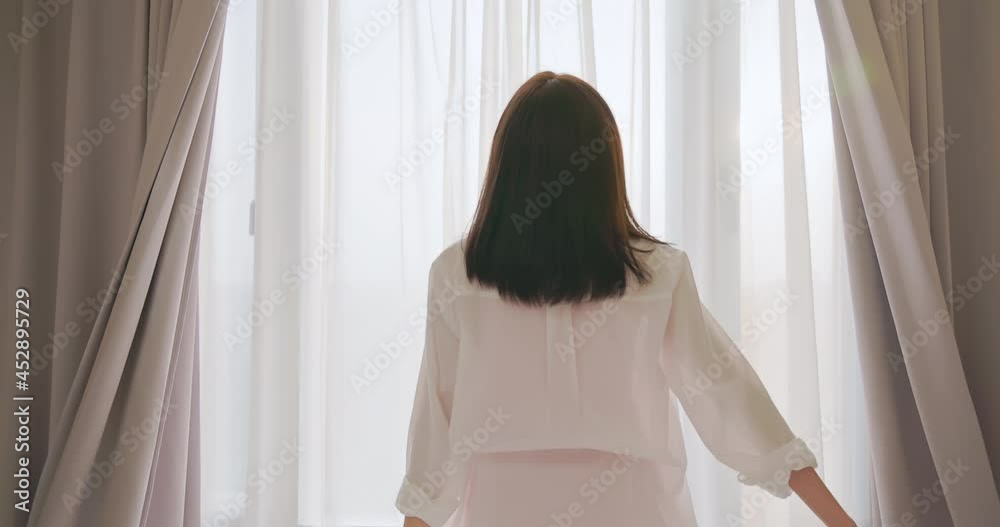 woman opens curtain woman opens curtain