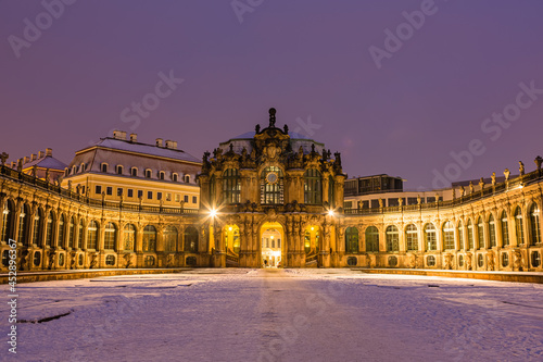 ドイツ ドレスデンのライトアップされたツヴィンガー宮殿と雪の積もった庭園