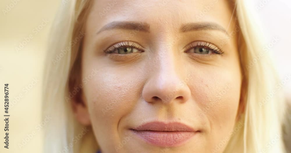 Close up shot of Caucasian young millennial woman face outdoor in city looking at camera in good mood. Beautiful blonde female standing on street. Face, deep look, emotions concept Close up shot of Caucasian young millennial woman face outdoor in city looking at camera in good mood. Beautiful blonde female standing on street. Face, deep look, emotions concept
