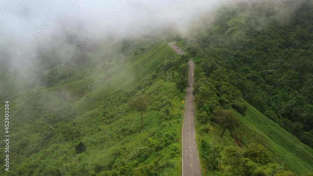 Aerial view of countryside road passing through the lush greenery and foliage tropical rain forest mountain landscape in the Northern Thailand, Nan province. Doi phuka