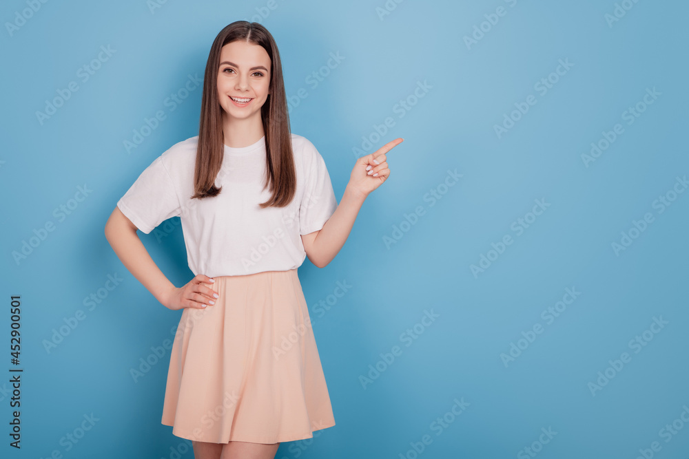 Portrait of adviser positive charming lady finger direct empty space on blue background Portrait of adviser positive charming lady finger direct empty space on blue background