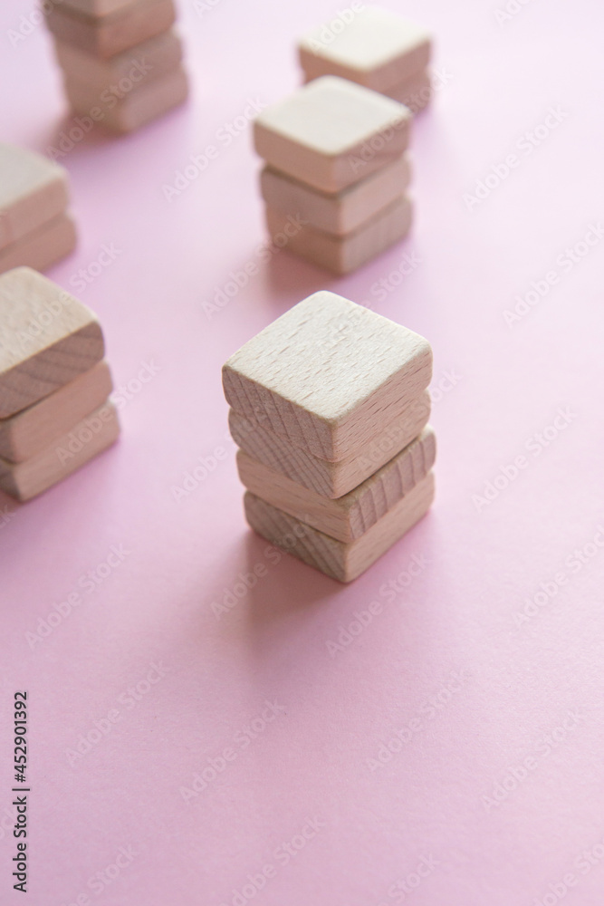 Set of stacks of wooden cubes on a pink background. Concept of team building Set of stacks of wooden cubes on a pink background. Concept of team building