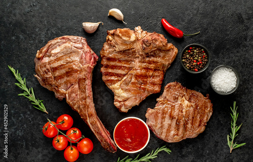 Variety of grilled beef steaks. Ribeye steak, tomahawk, T-bone, on a stone background