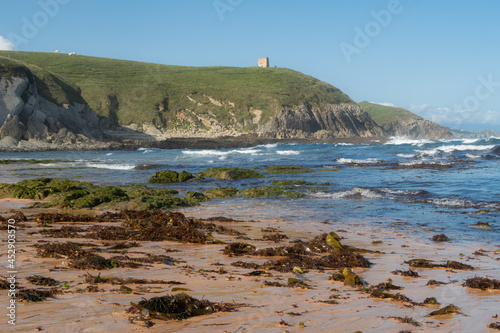 Tagle beach in Cantabria with tower in the background photo