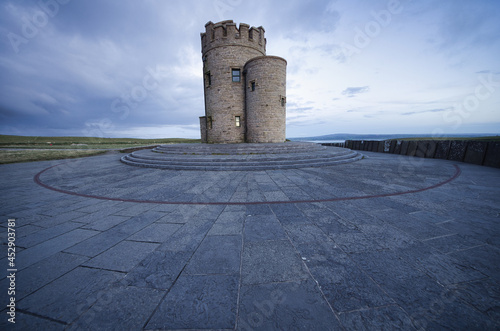 Shot of the O'Brien's Tower on the cliffs of Moher in Ireland under a cloudy blue sky. photo