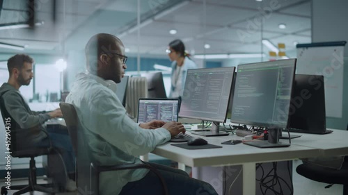 Wallpaper Mural Multi-Ethnic Office: Black IT Programmer Working on Desktop Computer. Male Specialist Doing Website, Software Engineer Developing App, Program, Video Game. Terminal with Coding Language. Static Shot Torontodigital.ca