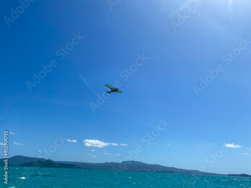 Ultra light airplane over a blue lagoon © aylerein