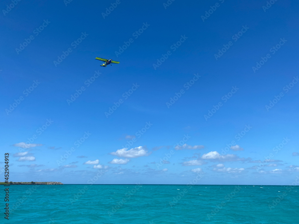 Ultra light airplane over a blue lagoon Ultra light airplane over a blue lagoon