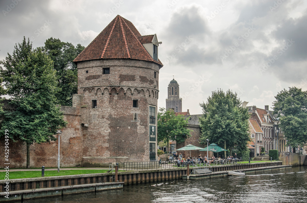 Zwolle, The Netherlands, August 20, 2021: historic tower and parts of the city wall as well as Torbecke canal under a dramatic sky