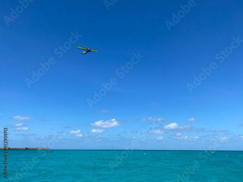 Ultra light airplane over a blue lagoon