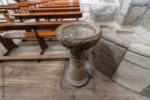 фотографія Classic baptismal font, made of a stone of granite, used for baptism in a europe
