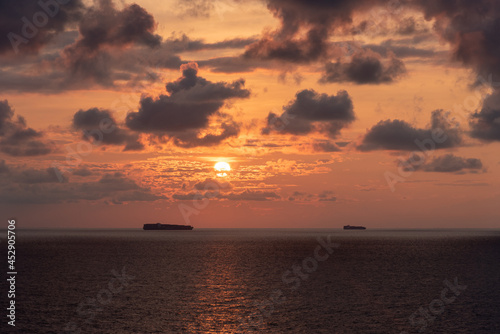 Mystical and inspirational beautiful sunset cloudy sky, over the calm ocean.