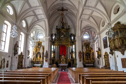 Great view of the high altar as well as the two smaller side altars next to each other on the same wall sides inside the parish church of St. Andreas in Berchtesgaden, Bavaria, Germany.