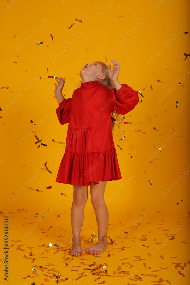 Fototapeta premium beautiful happy blonde girl in a red dress is happy jumping holiday birthday