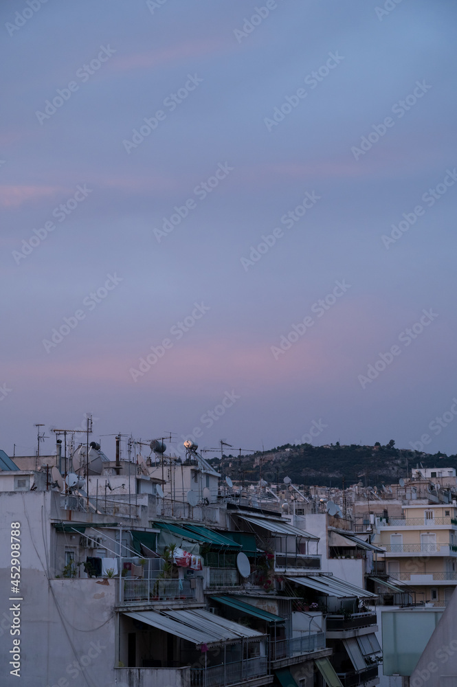 Cityscape of residential area in Athens at evening twilights. Urban architecture. Mountain on background.