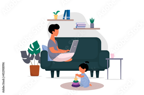 Work at home, freelance computer. A young man uses a laptop, works or studies, sitting at home on the couch, a child plays in the room.
