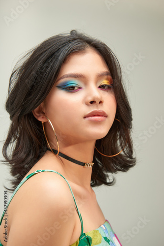 Portrait of young woman with funny rainbow colored make-up