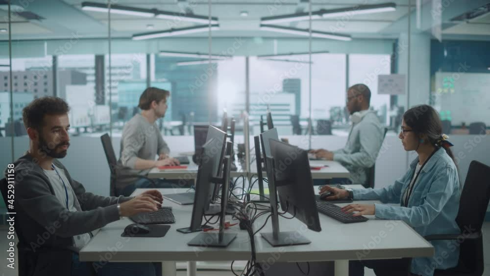 Diverse Multi-Ethnic Team Working in Big City Office: IT Programmers Working on Desktop Computers. Specialists Creating Innovative Software. Engineers Developing Inspiration App, Program. Wide Shot