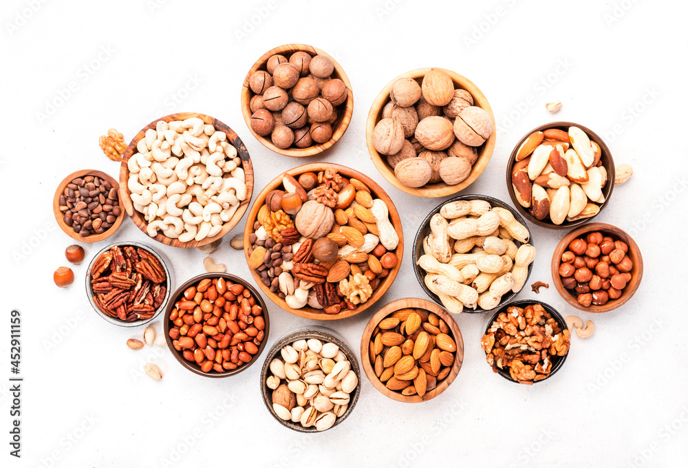 Nuts in bowls. Almonds, hazelnuts, walnuts and other. Healthy food snack mix on white table, top view, copy space Nuts in bowls. Almonds, hazelnuts, walnuts and other. Healthy food snack mix on white table, top view, copy space