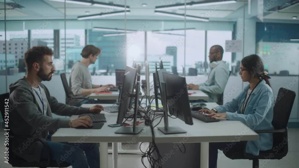 Diverse Multi-Ethnic Team Working in Big City Office: IT Programmers Working on Desktop Computers. Specialists Creating Innovative Software. Engineers Developing Inspiration App, Program. Wide Shot