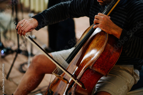 Cellist spielt Musik auf einem Cello mit Bogen. Geringe Schärfentiefe und selektive Schärfe 