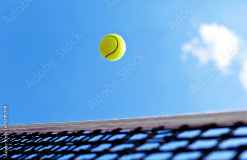 Tennis ball flying over a net
