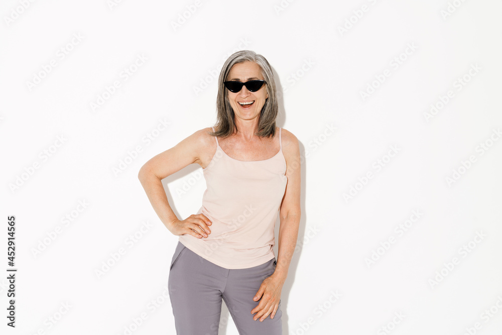 Senior woman wearing sunglasses laughing at camera Senior woman wearing sunglasses laughing at camera