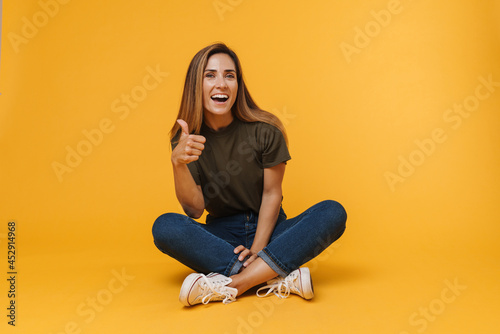 Smiling mid aged casual woman sitting on a floor © Drobot Dean