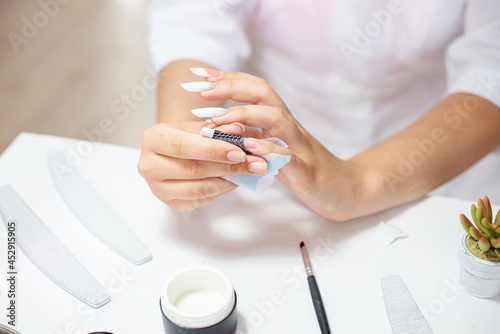 Master performing a professional manicure on herself at beauty salon. On-line manicure training course. Beautician student practicing manicure on herself. Nail beauty blogging. Manicurist hands