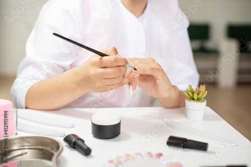 Master performing a professional manicure on herself at beauty salon. On-line manicure training course. Beautician student practicing manicure on herself. Nail beauty blogging. Manicurist hands