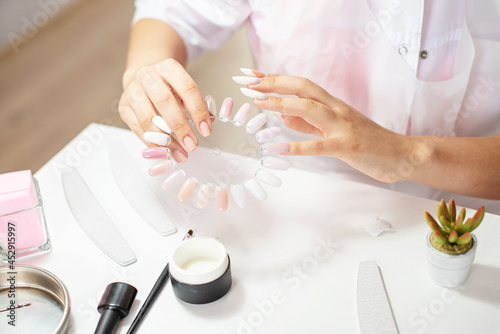 Master performing a professional manicure on herself at beauty salon, on-line manicure training course. Self-care manicure. Beautician student practicing manicure on herself. Nail beauty blogging