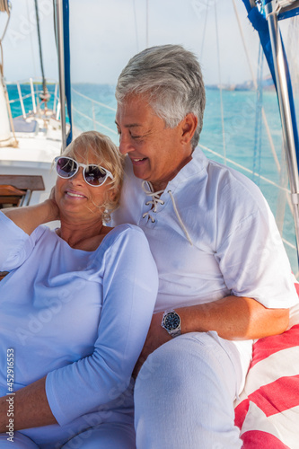 Senior couple, enjoying sailing trip on a luxury summer holiday vacation, sunny weather and ocean in background, love and romance on a beautiful yacht