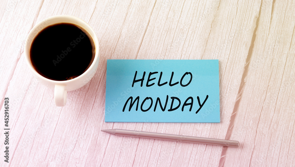 HELLO MONDAY text on the blue sticker with cofee and pen HELLO MONDAY text on the blue sticker with cofee and pen