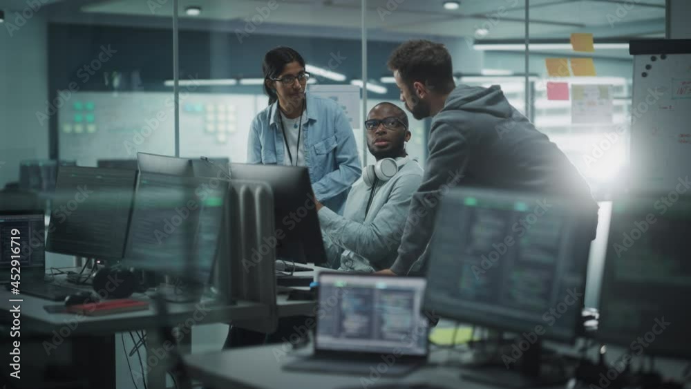 Diverse Team in Modern Office: IT Programmers Gather Around Computer, Talking, Finding Solution. Specialists Create Software. Engineers Develop App, Program. Rack Focus Computers to People
