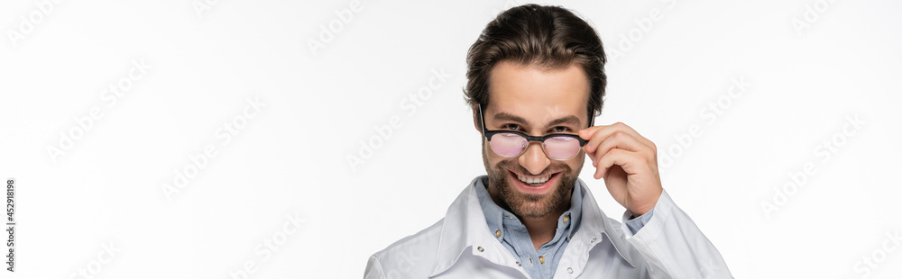Doctor holding eyeglasses while smiling at camera isolated on white, banner Doctor holding eyeglasses while smiling at camera isolated on white, banner