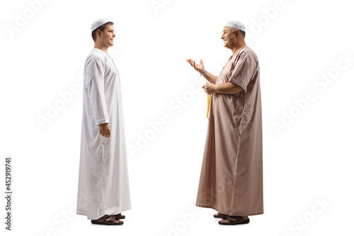Full length profile shot of a father and son in ethnic clothes having a conversation
